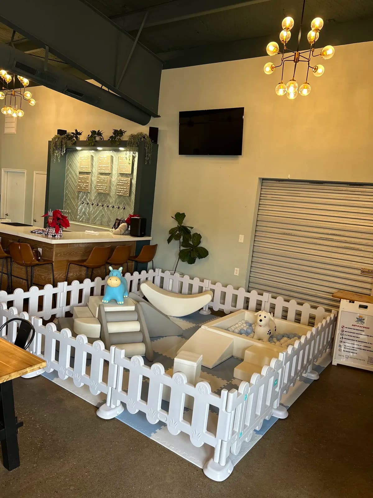 Soft play corner with slide and picket fence at an indoor event venue