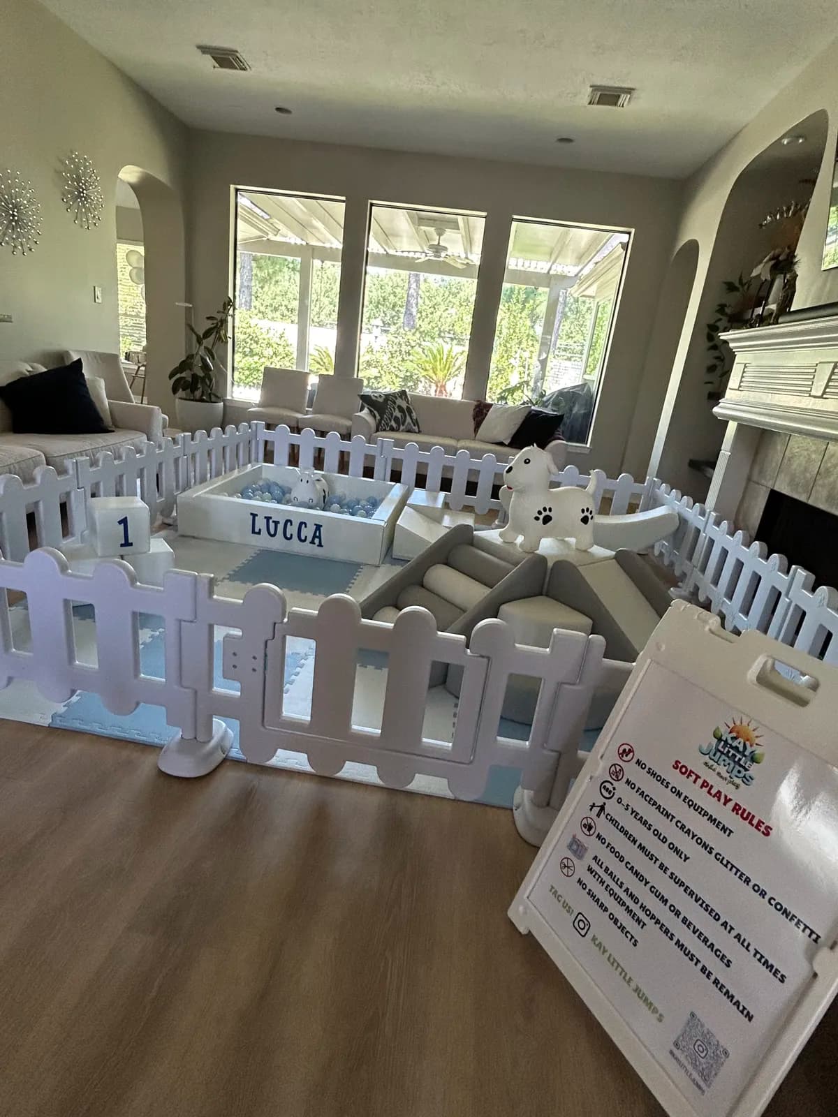 White picket-fence soft play with a personalized ball pit in a living room